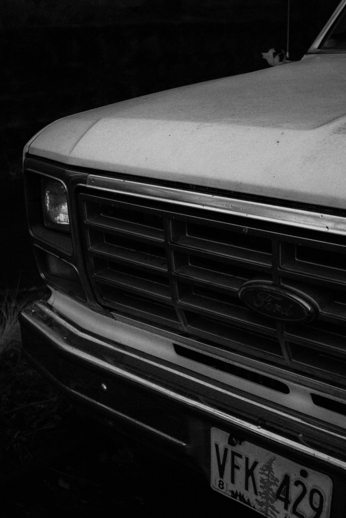 Photo by Zachary Keimig. 1970s Ford truck. Front end. Black and white photograph. 2688 x 4032