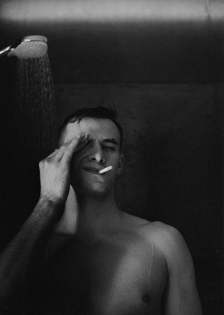 Photo Svetlana Gorley. Young man in shower with cigarette. Black and white photography.